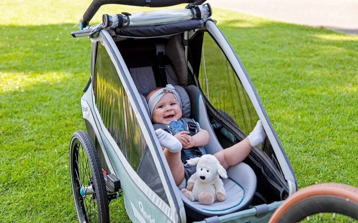 Kind sitzt komfortabel im Qeridoo Fahrradanhänger